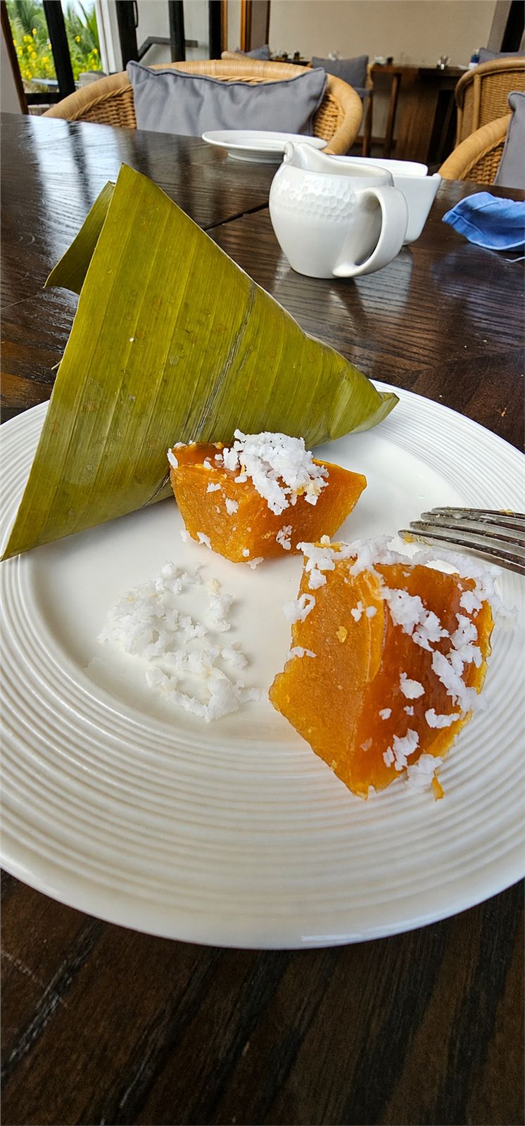 Kutsinta with fresh coconut beside a banana-leaf parcel
