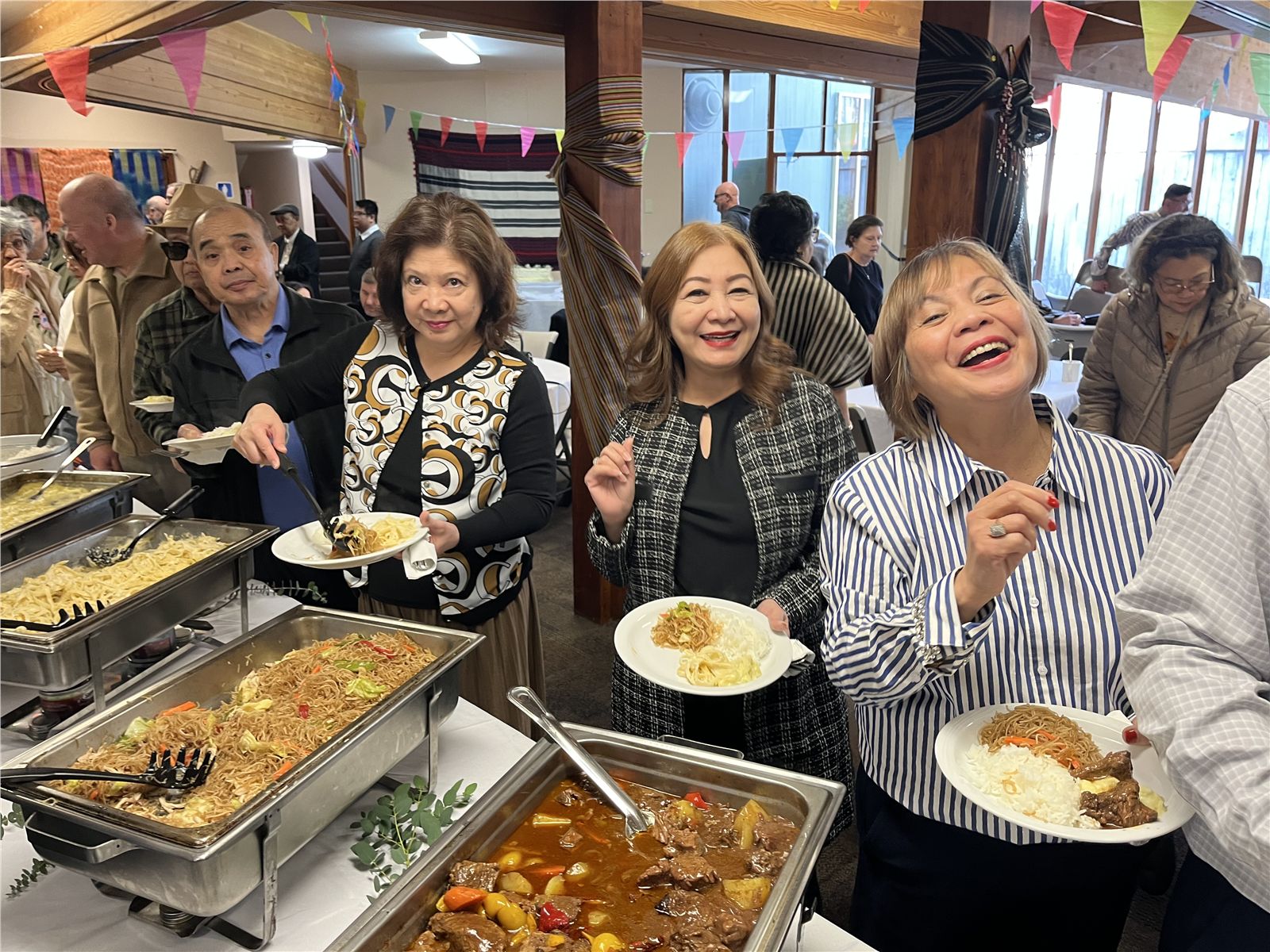 A joyful Filipino celebration gathered around a generous buffet